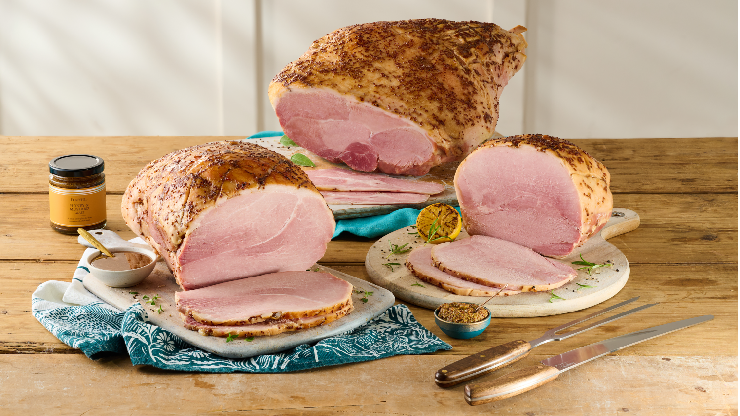 Three honey glazed ham joins sliced on a table.