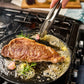 wagyu sirloin steak being cooked in pan